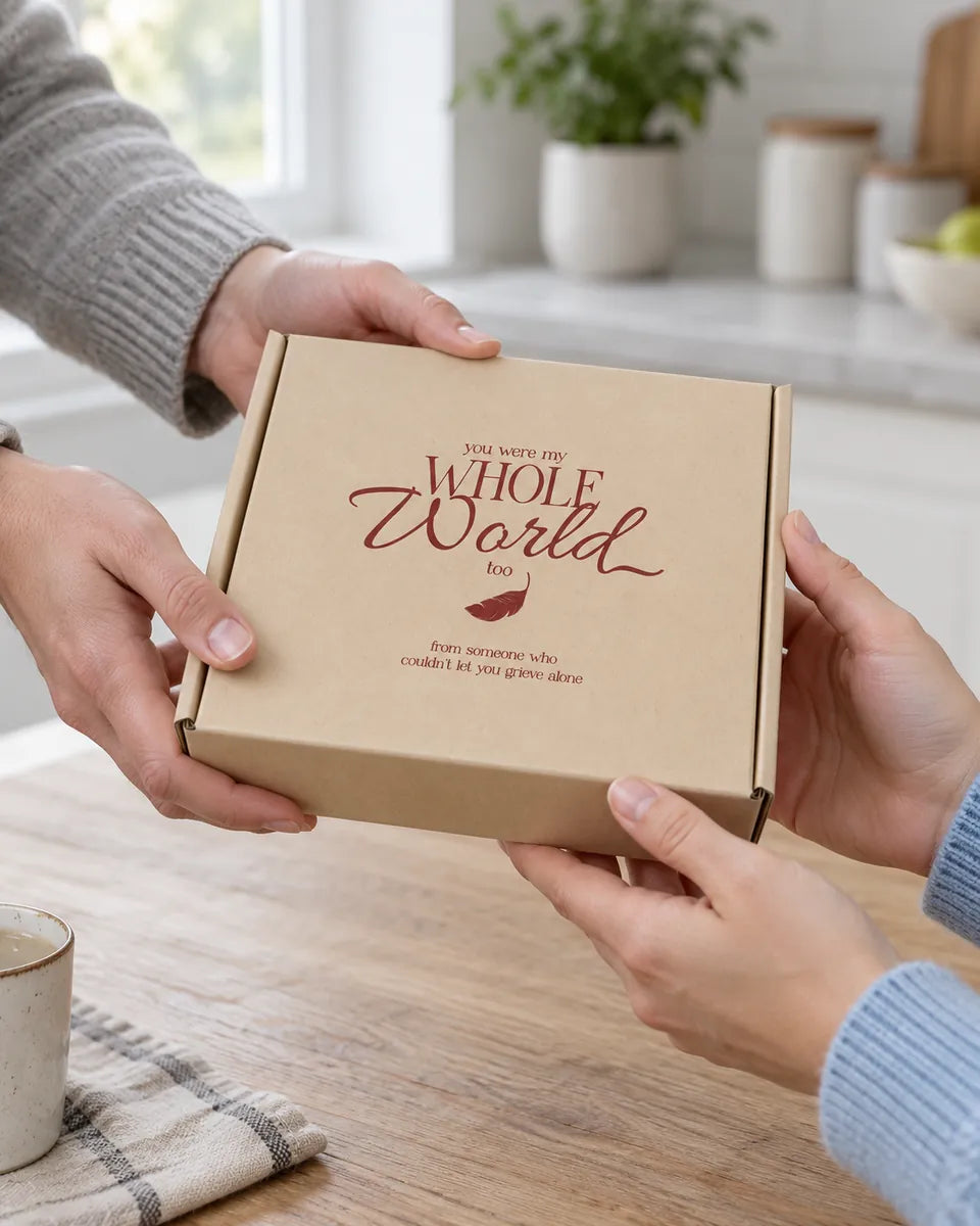 One person passing the kraft gift box to another across a kitchen table
